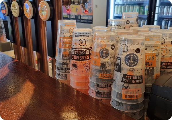 Venues use reusable cups to save money and cut on waste, with stacks of bettercup reusable tumbler cups sitting on a bar at a live music venue.