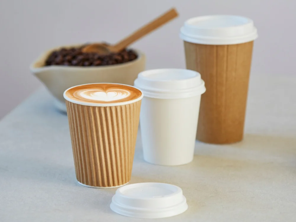 Disposable and compostable coffee cups being used instead of reusable cups at a cafe.